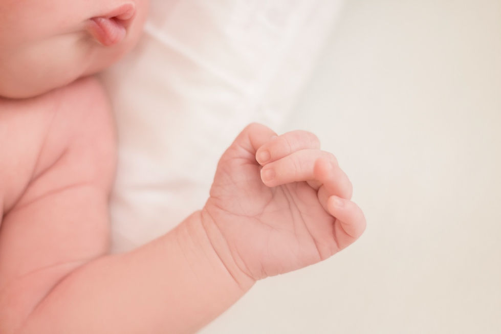 Baby's hand resting on a soft surface.