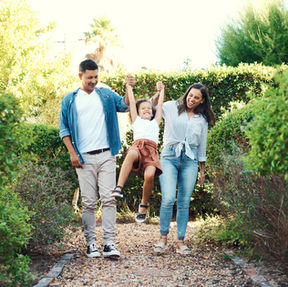 A happy young family enjoying a walk in a park.