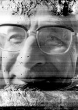 A close-up black-and-white portrait of the author's father-in-law, concluding the *Entropie* series. The man wears glasses and gazes past the lens with a serene expression. Film degradation is concentrated along the top and bottom edges, creating an organic, jagged frame reminiscent of ice or coral, while leaving the face sharp at the center of a luminous, architectural composition.