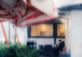 Fotografia d'arte del febbraio 2026, premiata su 1X.COM. Realizzata con tecnica ICM e stacking, l'opera ritrae un uomo seduto in un caffè urbano, protetto da una grande tenda rossa a strisce. Mentre la città esterna si dissolve in una trama astratta di luci e nebbia, il soggetto rappresenta un momento di rifugio e introspezione nel cuore del dinamismo cittadino