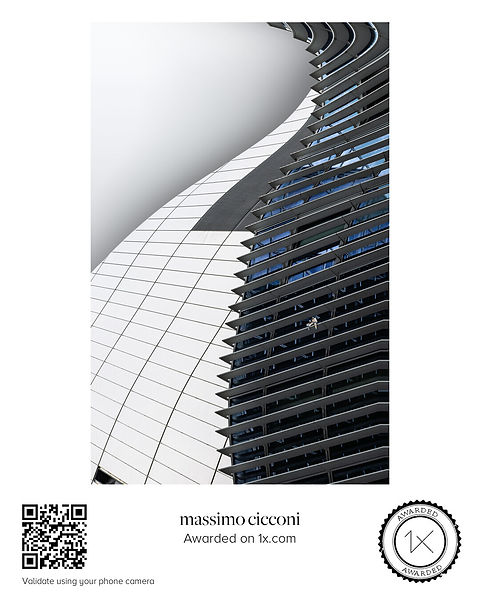 Fotografia d'architettura concettuale intitolata Invisible Threads. L'imponente facciata curva e geometrica del Montevetro Villa sovrasta una minuscola figura di donna di colore al telefono con il suo bambino. L'immagine rappresenta visivamente la solitudine, la distanza dalla famiglia e il legame sospeso con la propria terra d'origine.