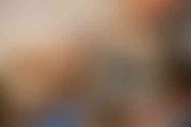 A Polaroid, vintage postcards, pen, and Parisian newspapers lay on a table.