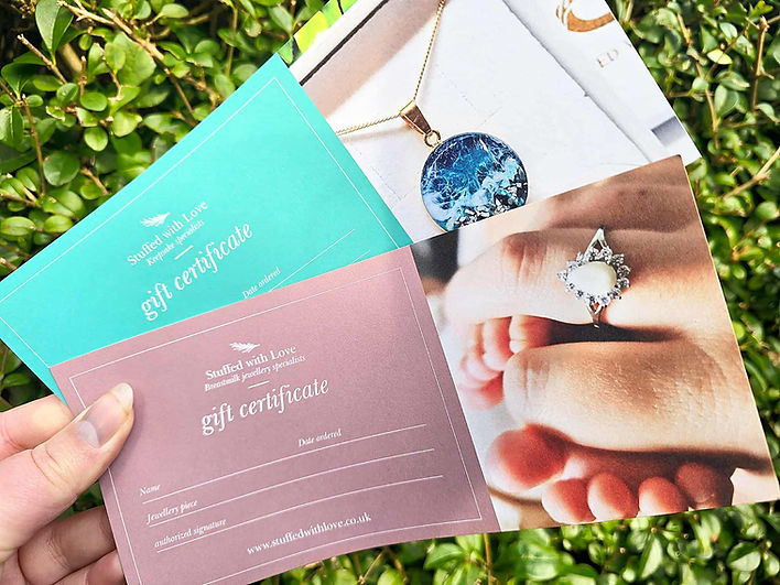 Gift vouchers for SWL Keepsakes displayed with a blue card and keepsake jewellery, presented on a leafy background.