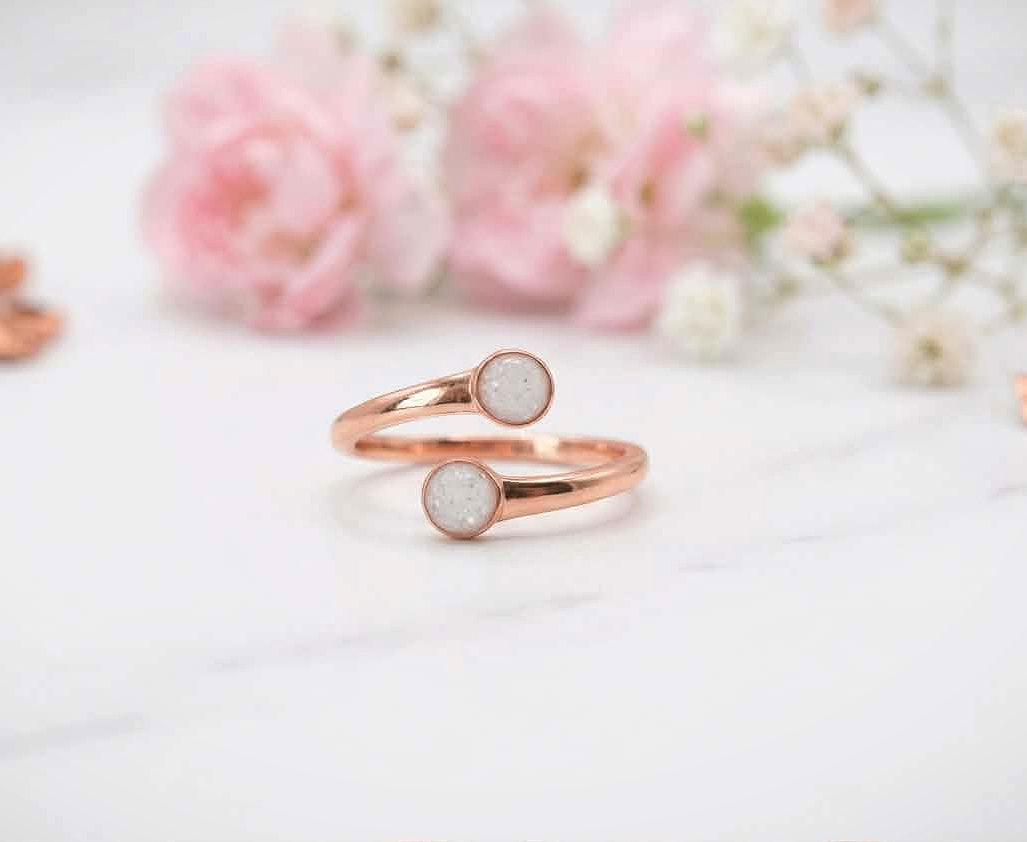 Rose gold adjustable ring with two 4mm breastmilk stones on blush wool backdrop
