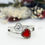 Thumbnail: Sterling silver double heart ring featuring a red ashes stone with silver leaf accents, set beside a clear zircon heart.