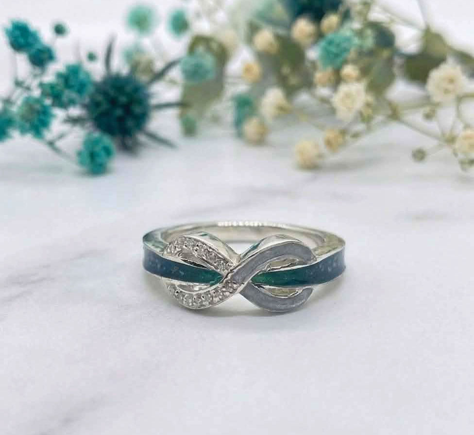 Ashes memorial crossover ring with two resin channels containing cremation ashes and birthstone crystals.