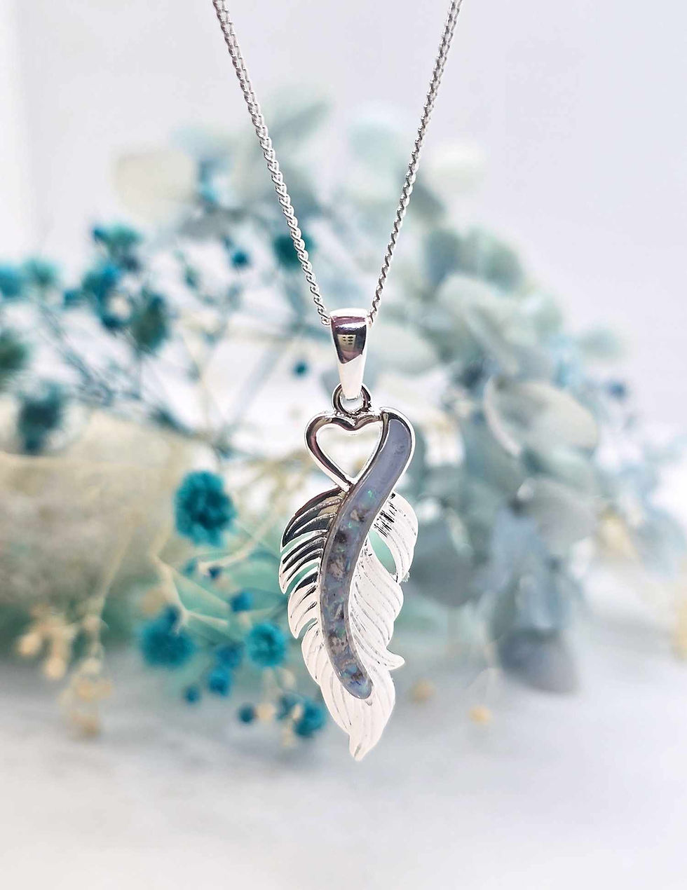 Thumbnail: Close-up of Nevaeh pendant on chain, sunlight hitting the curve of the wing