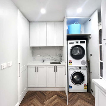 Laundry renovation Sydney with stacked washer dryer and custom cabinetry for efficient storage