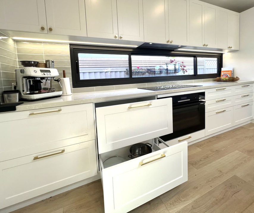 Custom kitchen renovation in Earlwood featuring white shaker cabinetry, stone benchtops, soft-close storage, and timeless custom joinery by Swish Kitchen.