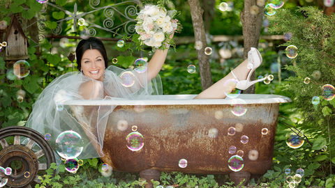 A windsor bride laughing in a bathtub at Chalet Studio
