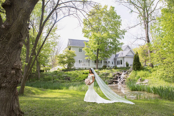 A Windsor bride relaxes by the pond and waterfall at Chalet Studio Photography & Gardens 