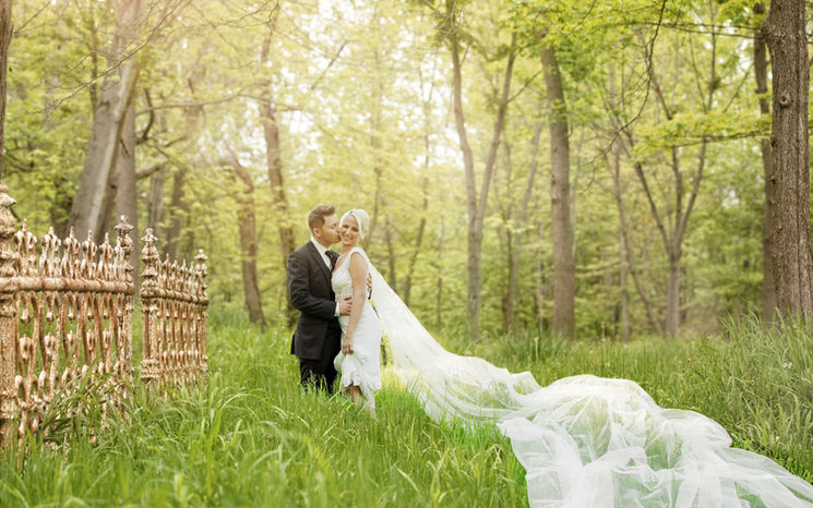 A Windsor bride and groom in the meadow grasses at Chalet Studio & Gardens with the vintage fence 