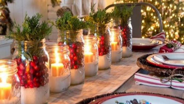 Potes de vidros com uma grossa camada de sal grosso dentro, dando suporte para uma vela, outros possuem dentro temos folhas e frutos vermelhos