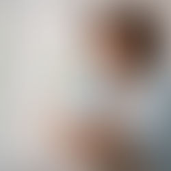 BIPOC adult sitting near a sunlit window in a calm, reflective moment, representing healing and trauma-informed therapy.