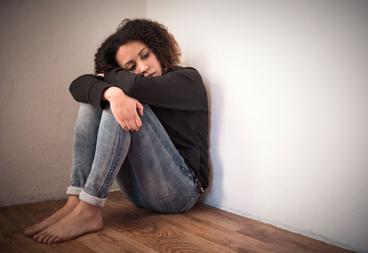 black woman sitting in a corner