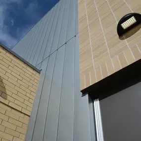 Close-up of a Montana building exterior with vertical metal siding and light brickwork 