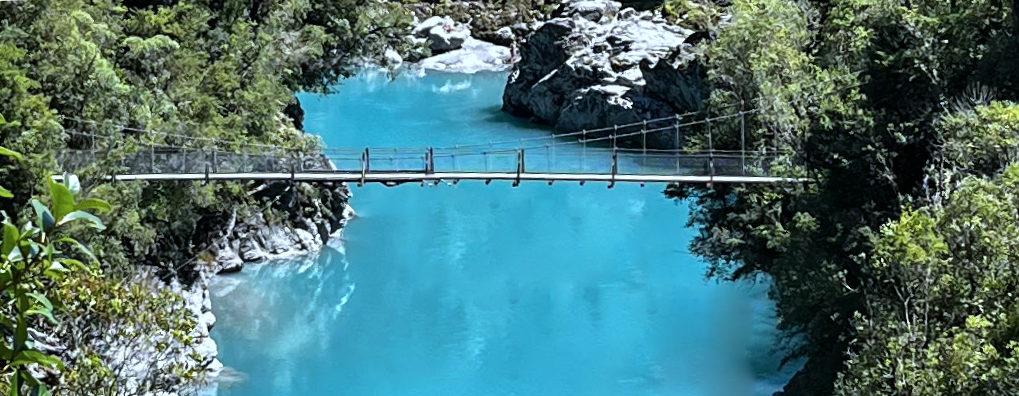 Suspension bridge over bright blue river
