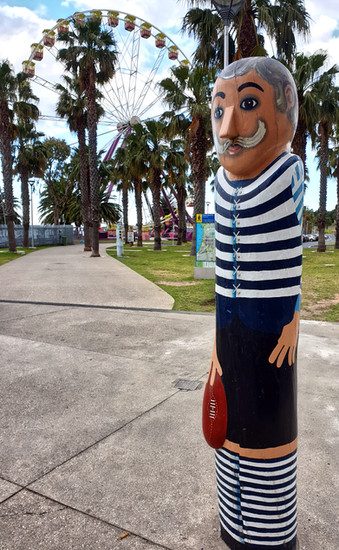 Sculpture of man with rugby ball, palm trees, Ferris wheel