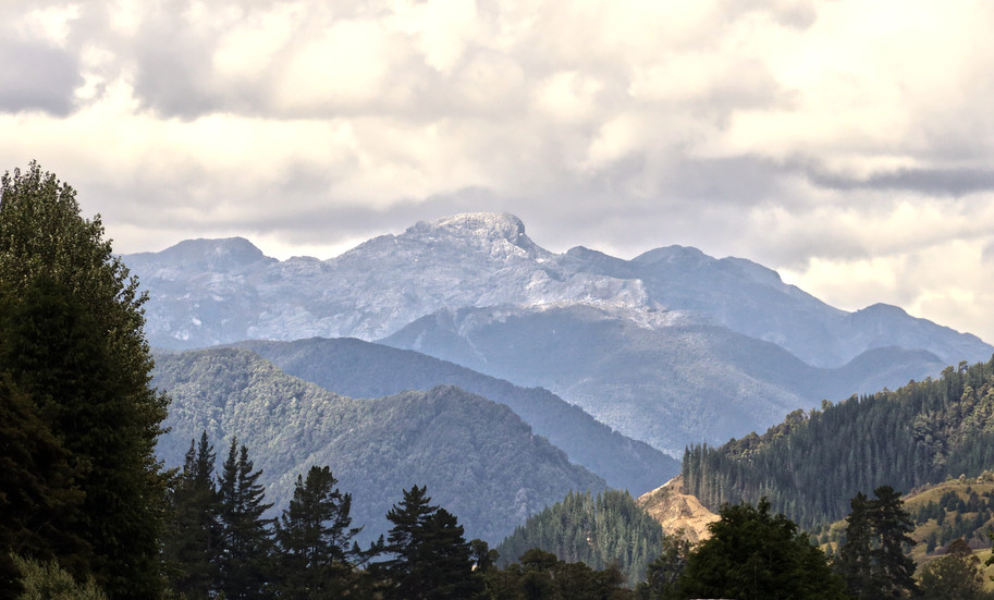 Layered mountain range under cloudy sky