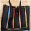 Thumbnail: Large Totebag, Black Magic Print, 100% cotton upholstery fabric, 1 front pocket, 1 back pocket on exterior, Color: Black striped with gray, red, royal blue, Special Features: 1 pocket on front, 1 pocket on back exterior, Cotton webbing strap, Black dimple vinyl bottom, 16-1/2"w x 15-1/2" L, JordynCherise