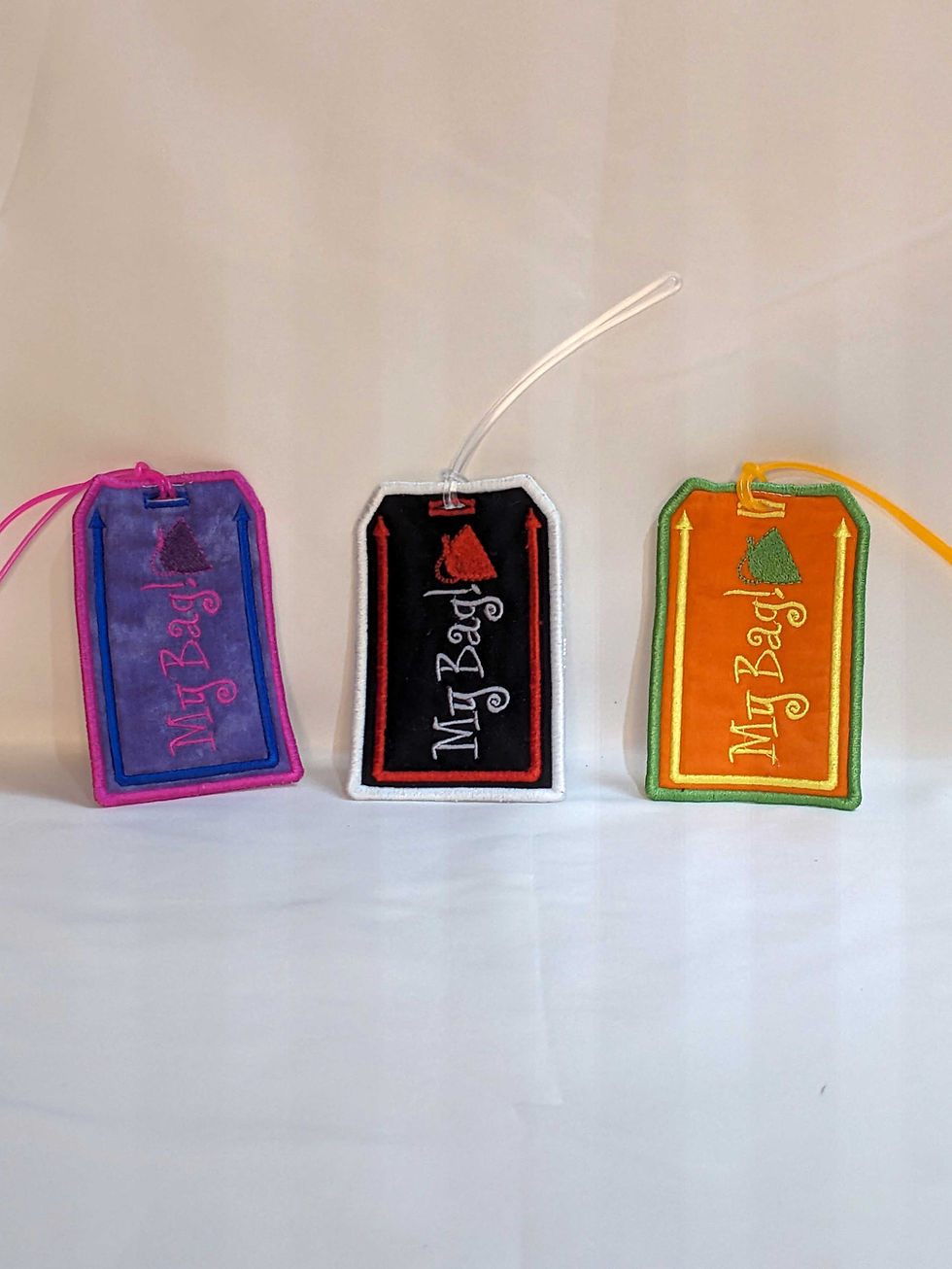 Thumbnail: Embroidered Luggage tag with message "My Bag!" Main Background Color: Purple, Black, Orange, Fabric: 100 % Cotton, Vinyl, Size: 3 x 4-1/2", Special Features: Embroidered lettering, design and borders, vinyl on back for name card, Vinyl loop attachment to hook to luggage, JordynCherise