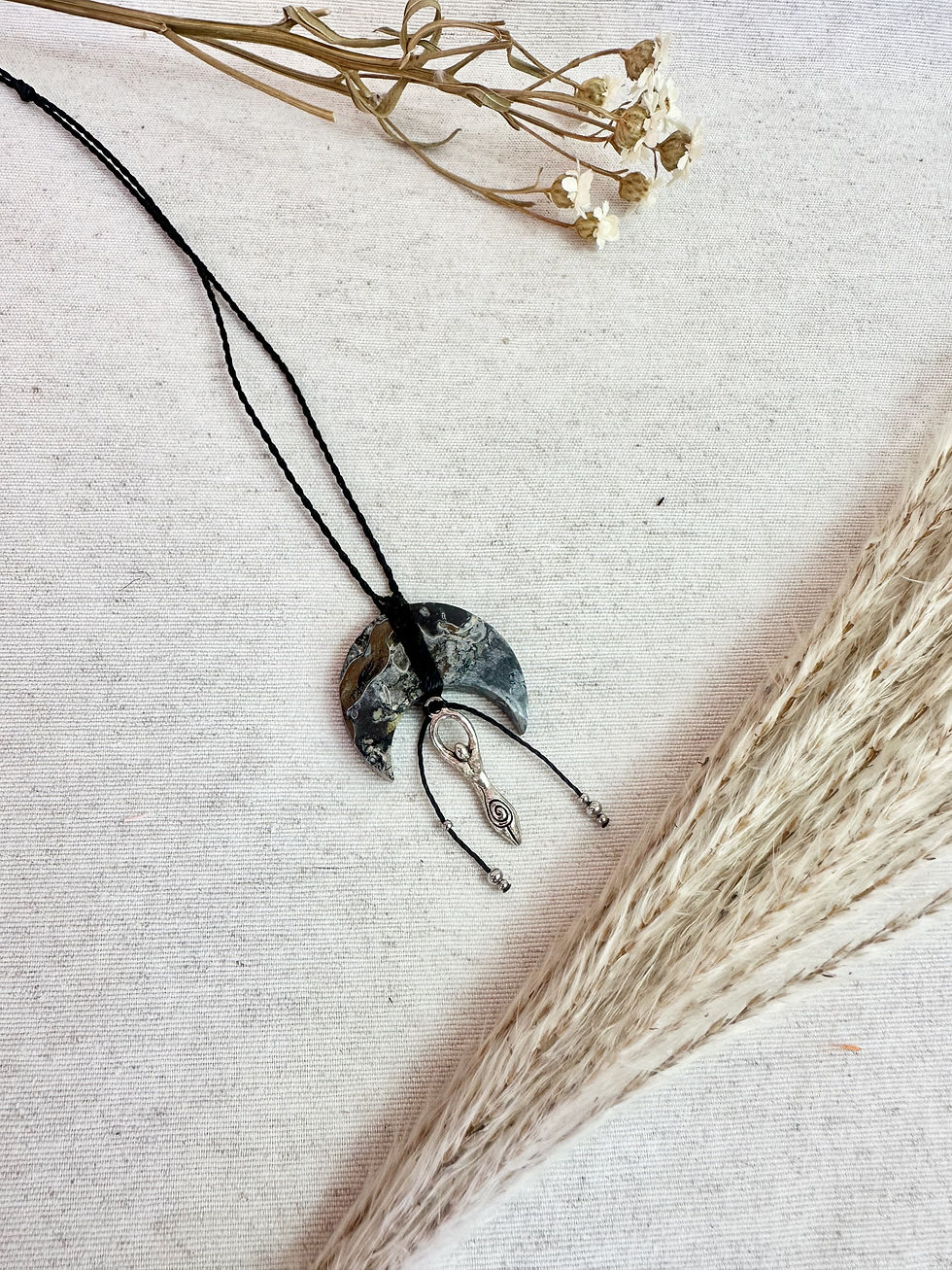 Collier réglable Gaïa Nocturne en racine de palmier fossilisée sur fond textile clair
