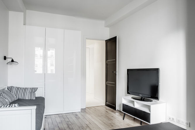 Pièce de vie claire avec télévision et parquet ancien