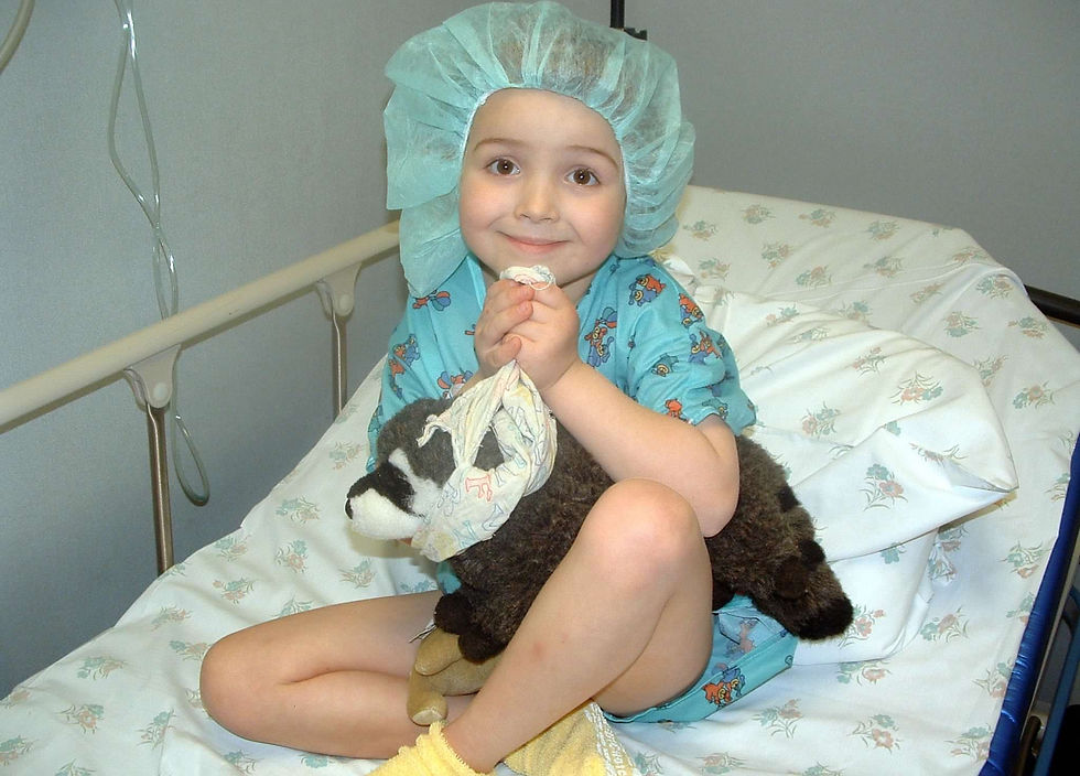A child sits in a hospital bed clutching a stuffed raccoon -- Chester from The Kissing Hand -- as a way to have comfort and strength.