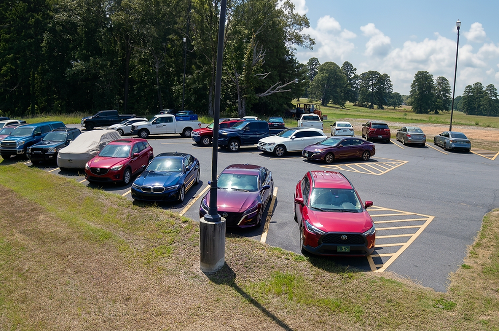 Parking lot with several cars parked on a sunny day.
