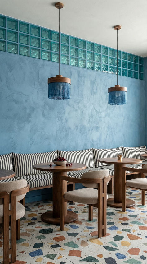 Diseño interior para restaurante pequeño con banca corrida, mesas compactas, acabados claros, iluminación decorativa y atmósfera moderna.