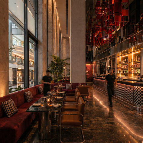 Interiorismo comercial para restaurante con barra, iluminación arquitectónica, mobiliario, materiales oscuros y atmósfera premium para experiencia gastronómica.
