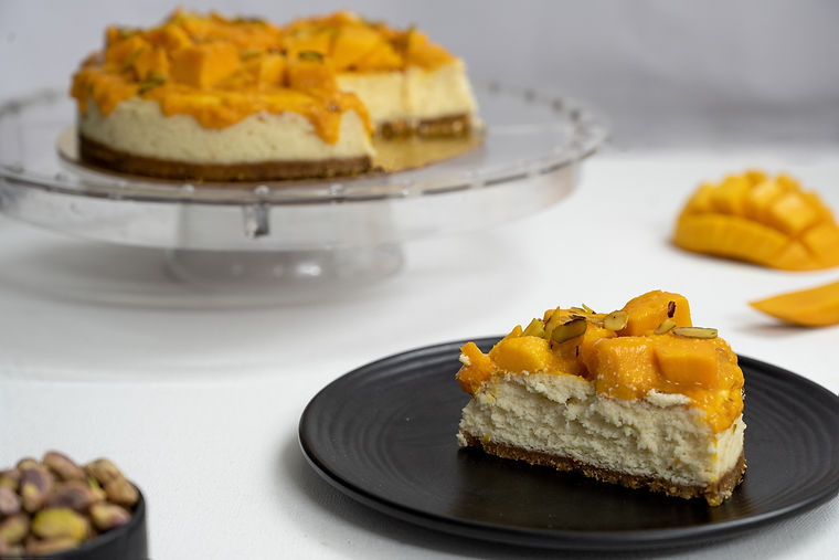 cut mango cheesecake slice with pistachio  grate