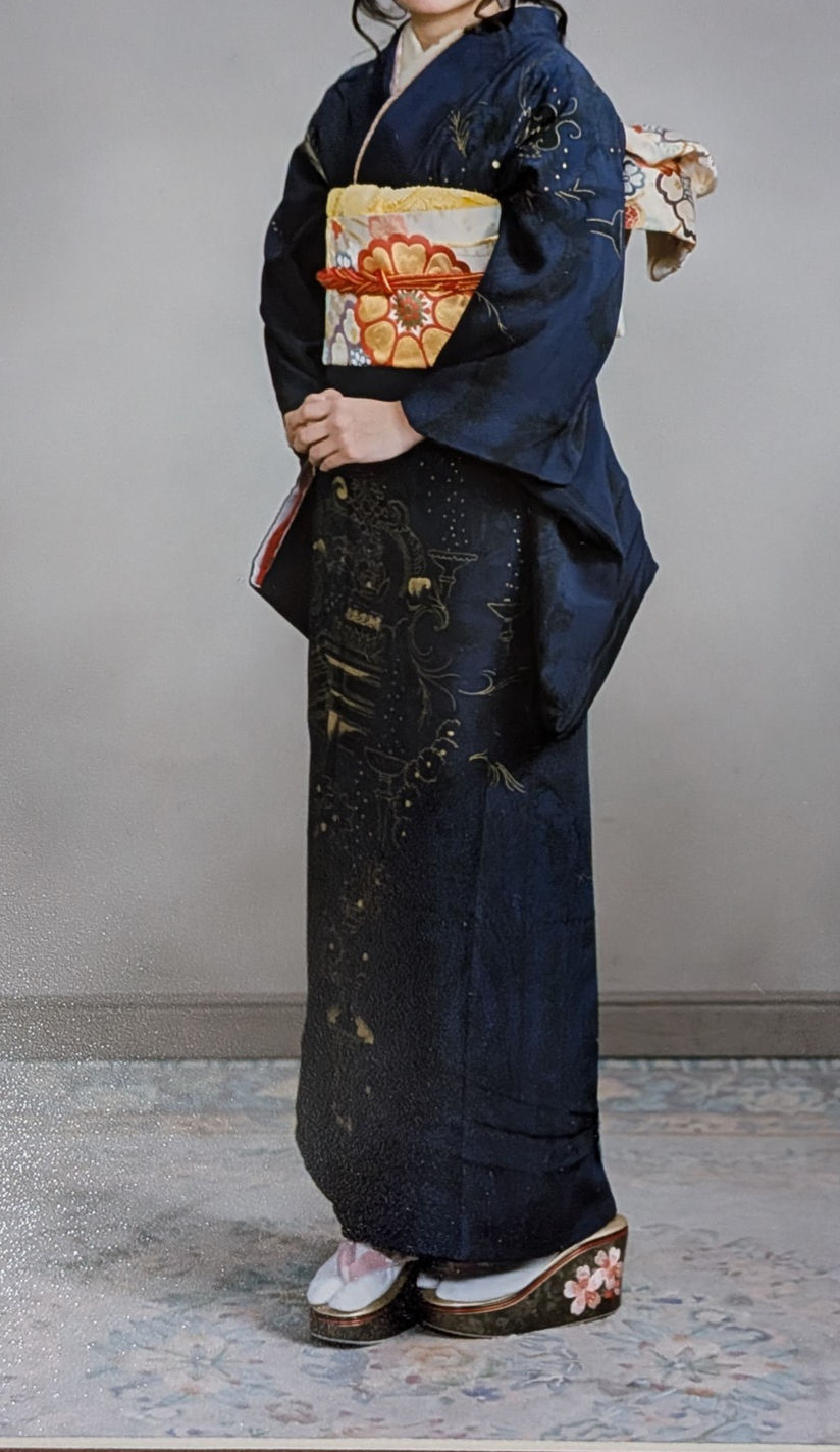 A young Japanese woman in a deep indigo-violet furisode with enigmatic gold leaf details, photographed at her coming-of-age ceremony in 2010s Tokyo.