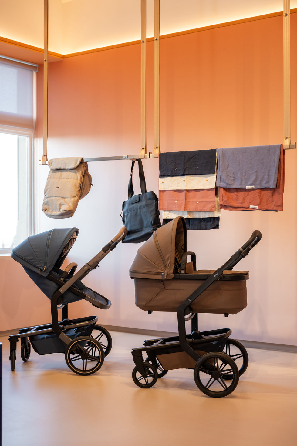 Strollers and bags displayed in a stylish showroom.