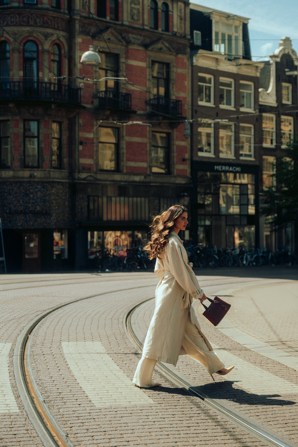 Woman walking across street in urban setting.