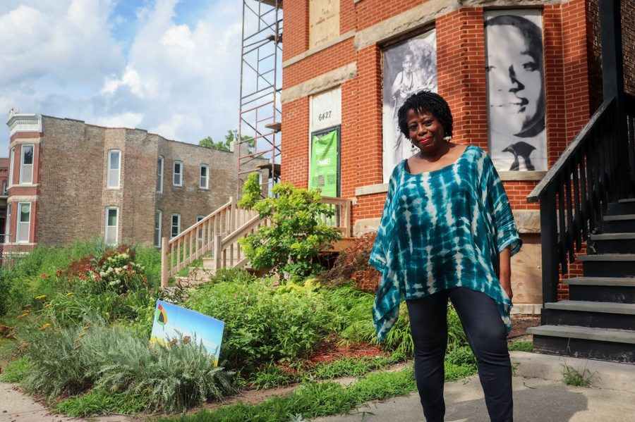 A woman standing in front of a historical home.