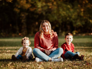 3 siblings sitting in the all grass
