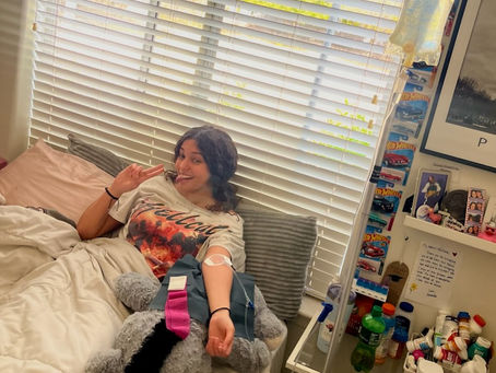 A relaxed woman reclines in bed while receiving an IV drip, enjoying professional in-home IV therapy for hydration, recovery, or symptom relief in a comfortable, private setting.