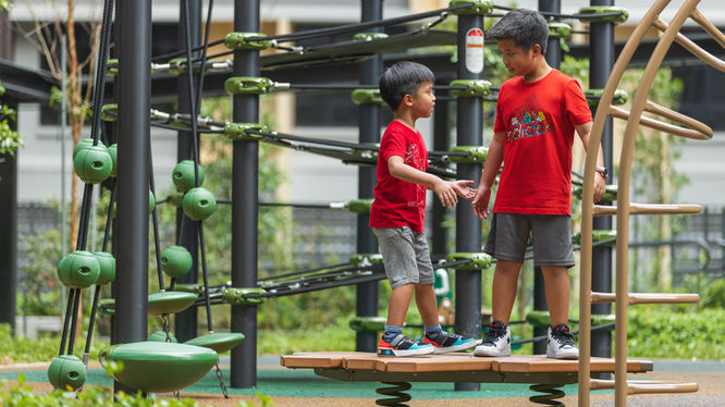 Two boys wearing red standing on an oak shape wobbling pad.