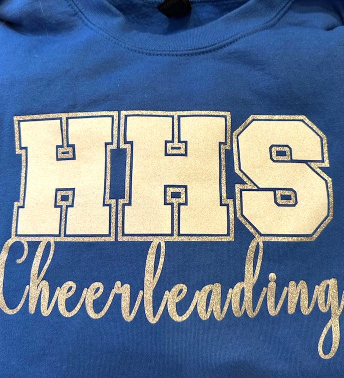 "HHS Cheerleading" screen printed on a blue shirt in white ink