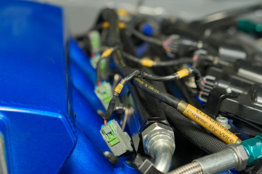 Engine wiring harness and connectors next to a blue component.