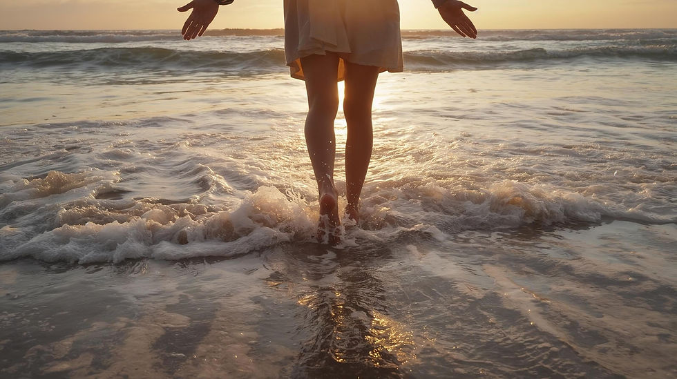 Person walks through shallow ocean waves at sunset, with golden light reflecting on water. Serene and tranquil beach scene. Solacium Therapy.