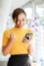 Happy businesswoman using smartphone with automated follow-up notifications, representing client engagement efficiency.