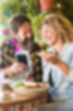 Joyful couple using smartphone with engagement icons, exemplifying personalized engagement tools at a cozy cafe.