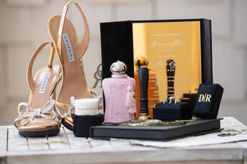 Gold high heels, pink perfume bottle, and luxury accessories