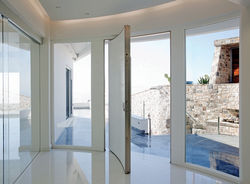 Curved Pivot Door covered with Corian and curved side parts made of glass. Handle made of Corian and