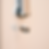 Silver bottle cap floats under a metallic dispenser mounted on a beige wall, casting a soft shadow. Minimalist and metallic theme.