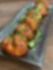 Spicy roasted mushrooms garnished with cilantro on a black rectangular plate, set on a wooden table. Earthy tones and vibrant greens.