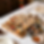 A wooden board with bowls of colorful sauces on a white table, surrounded by spices and bowls. Elegant, intricate designs on cups.