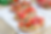 Slices of bruschetta topped with diced tomatoes and herbs sit on parchment paper. Wooden table backdrop, vibrant colors, fresh and inviting.